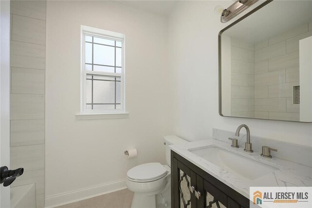 bathroom featuring vanity, tile patterned flooring, toilet, and walk in shower