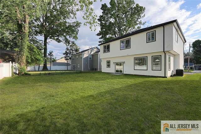 back of property featuring central AC and a lawn