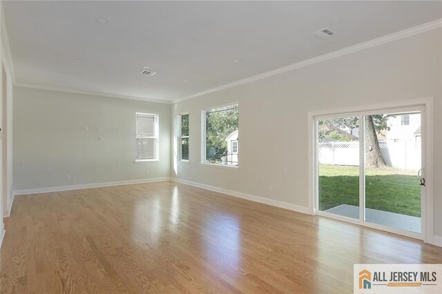 unfurnished room with light hardwood / wood-style flooring, ornamental molding, and plenty of natural light