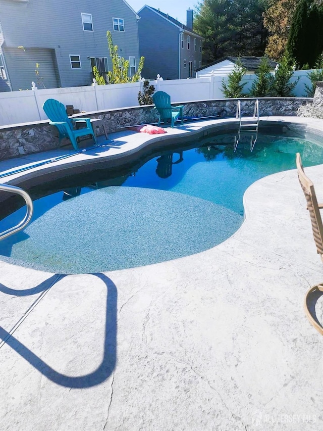 view of swimming pool featuring a fenced backyard, a fenced in pool, and a patio