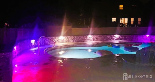 pool at twilight featuring a fenced in pool