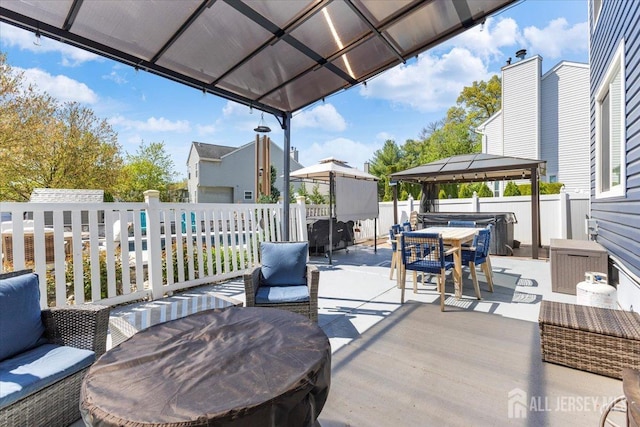 deck with fence, outdoor dining space, a gazebo, a hot tub, and a patio