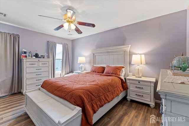 bedroom with ceiling fan, visible vents, and dark wood-type flooring