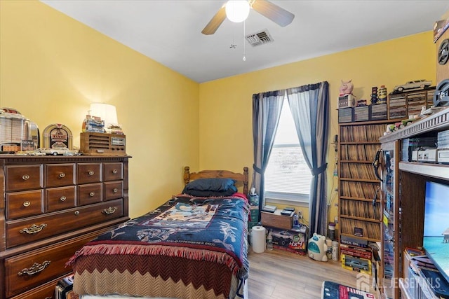 bedroom featuring ceiling fan, wood finished floors, and visible vents