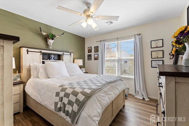 bedroom with visible vents, a ceiling fan, dark wood finished floors, and baseboards