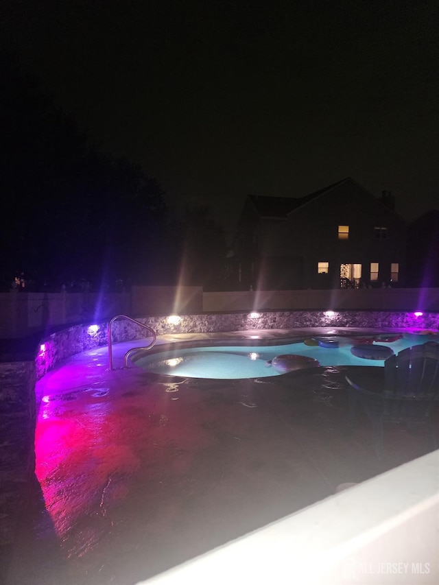 pool at night with a jacuzzi