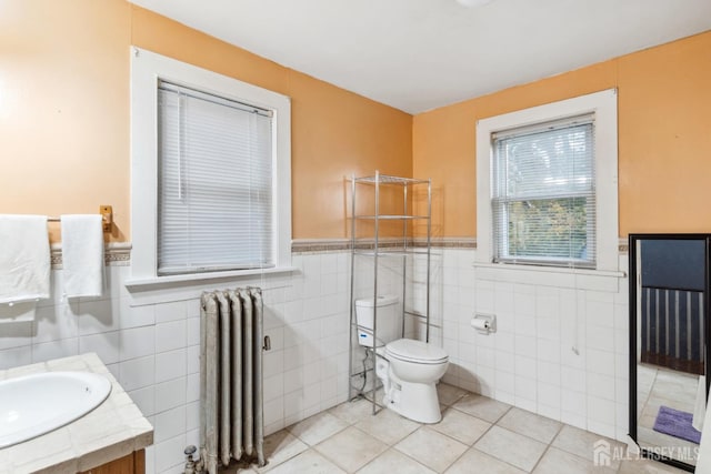 bathroom with tile walls, radiator, tile patterned flooring, and toilet