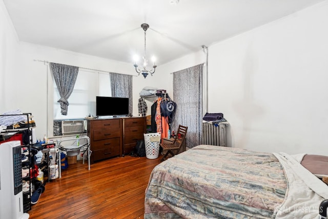 bedroom with a notable chandelier and dark hardwood / wood-style floors