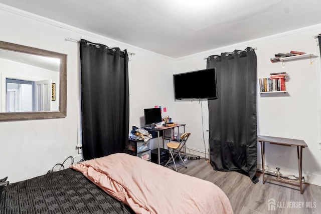 bedroom with hardwood / wood-style flooring and ornamental molding