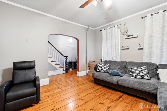 living room featuring hardwood / wood-style floors, crown molding, and ceiling fan