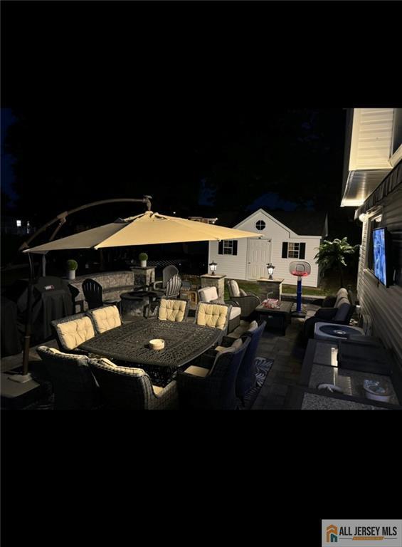 10 Buttonwood Dr, Old Bridge, NJ 08857 - patio at twilight featuring outdoor dining area and a patio area