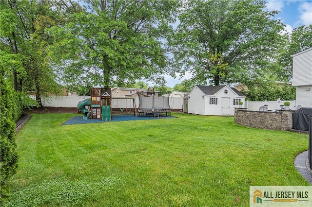 10 Buttonwood Dr, Old Bridge, NJ 08857 - view of yard with a trampoline, a playground, and an outbuilding