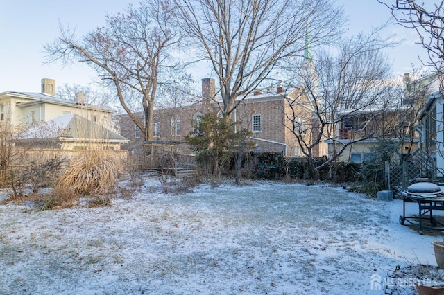 snowy yard featuring fence