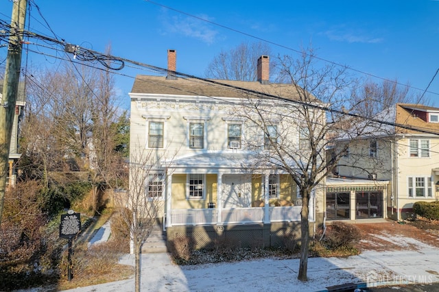 view of front of home with covered porch and a chimney