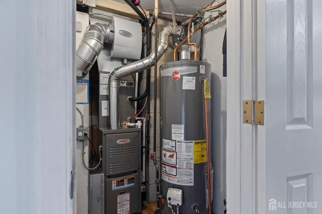 utility room featuring heating unit and water heater