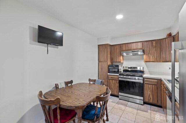 kitchen with light tile patterned floors and stainless steel appliances