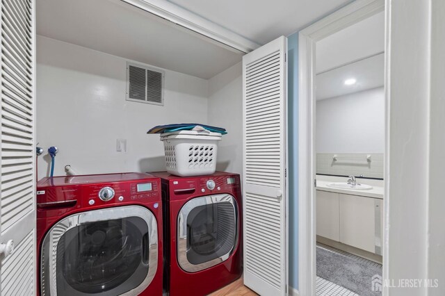 laundry area with washer and clothes dryer and sink