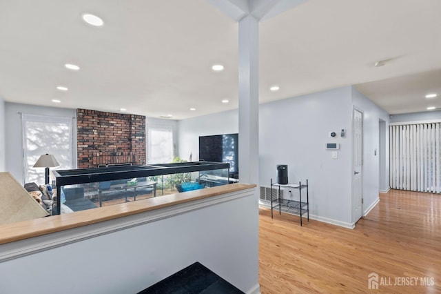 bar with a fireplace and light hardwood / wood-style floors