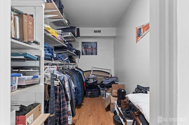 walk in closet with light hardwood / wood-style flooring