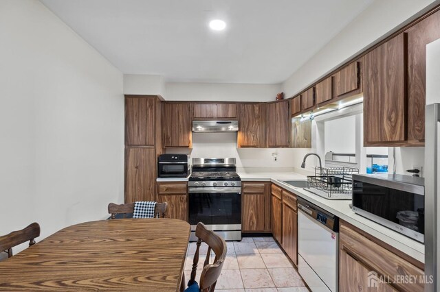 kitchen featuring appliances with stainless steel finishes, sink, and light tile patterned floors