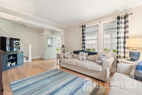 185 Rowland Pl, Woodbridge Proper, NJ 07095 - living room with wood finished floors, stairway, and crown molding