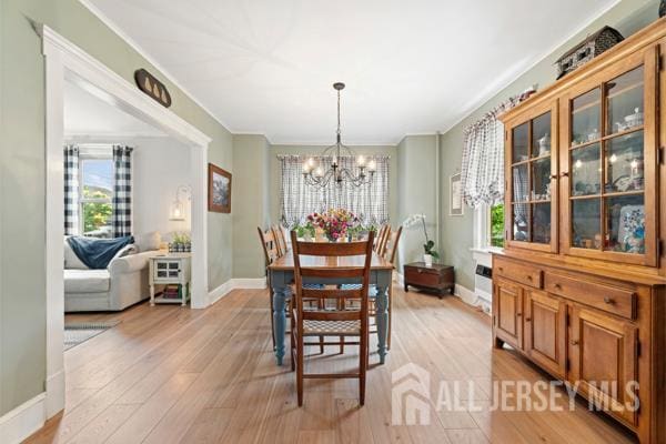 185 Rowland Pl, Woodbridge Proper, NJ 07095 - dining area featuring a chandelier, light wood finished floors, and ornamental molding