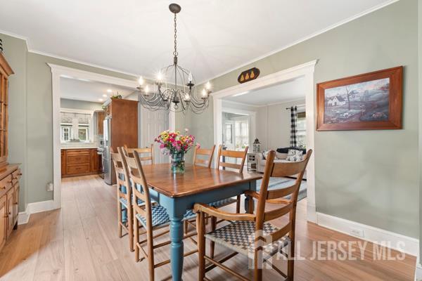 185 Rowland Pl, Woodbridge Proper, NJ 07095 - dining area with a chandelier, light wood-style flooring, and ornamental molding