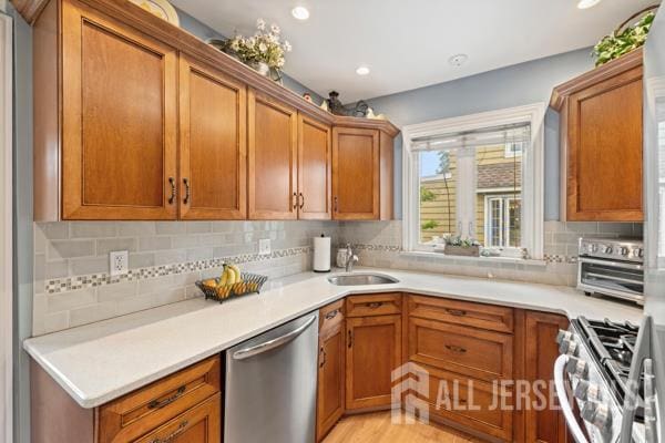 185 Rowland Pl, Woodbridge Proper, NJ 07095 - kitchen with stainless steel appliances, brown cabinets, decorative backsplash, light countertops, and recessed lighting