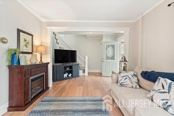 185 Rowland Pl, Woodbridge Proper, NJ 07095 - living area featuring stairs, wood finished floors, a glass covered fireplace, and crown molding
