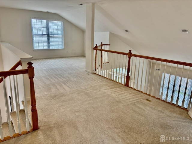 additional living space with baseboards, lofted ceiling, and carpet flooring