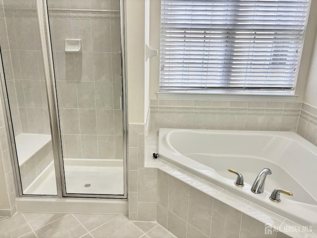 full bath with a garden tub, tile patterned flooring, and a shower stall