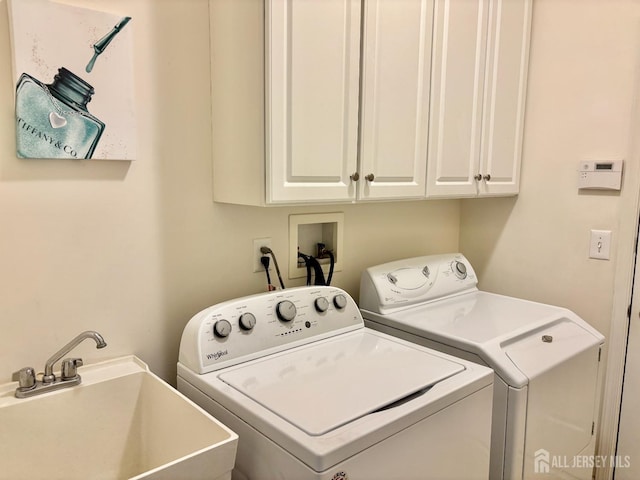 laundry area with washer and dryer, cabinet space, and a sink