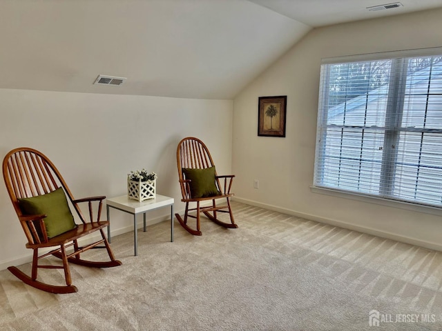 living area featuring baseboards, visible vents, carpet flooring, and vaulted ceiling