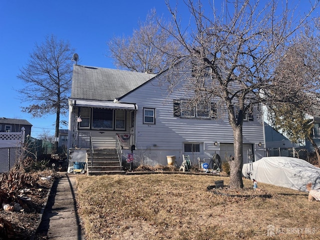 view of front of home with a garage, a shingled roof, concrete driveway, and fence