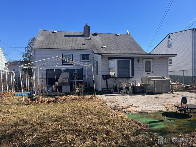 back of house featuring a patio, a yard, and a trampoline