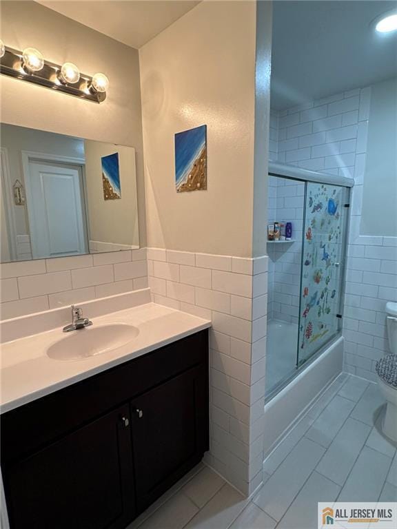 3205 Hana Rd, Edison, NJ 08817 - full bath with tile walls, vanity, bath / shower combo with glass door, a wainscoted wall, and tile patterned floors