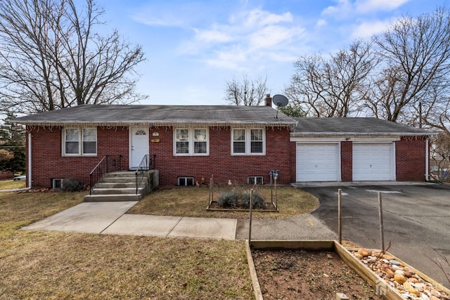 ranch-style house with a front lawn, an attached garage, brick siding, and driveway