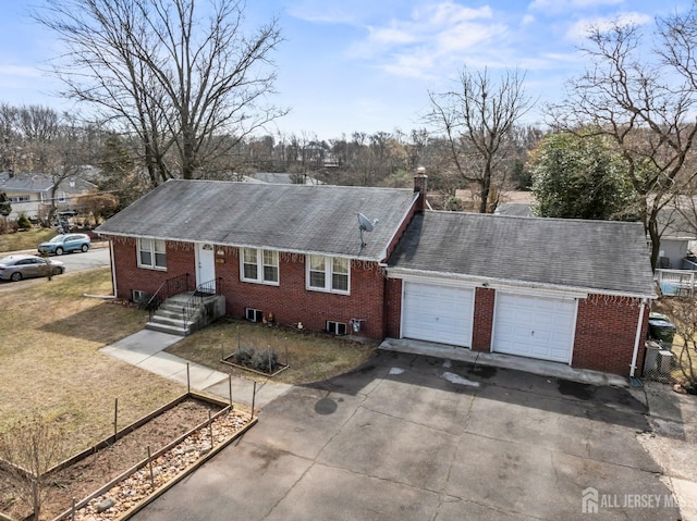 single story home with an attached garage, brick siding, and driveway