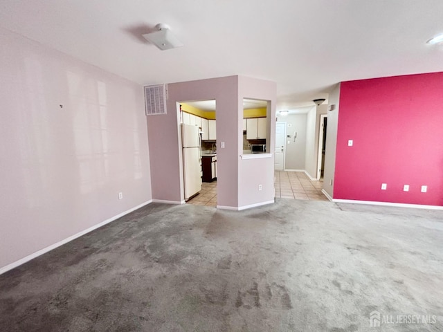 unfurnished living room with light carpet, visible vents, and baseboards