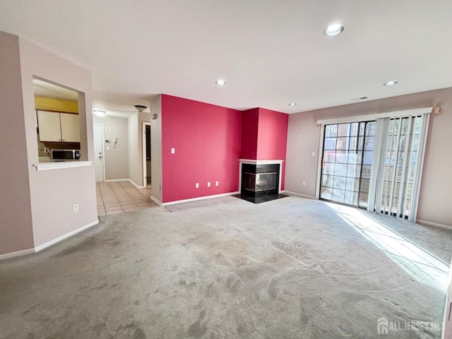 unfurnished living room with a wood stove and light carpet