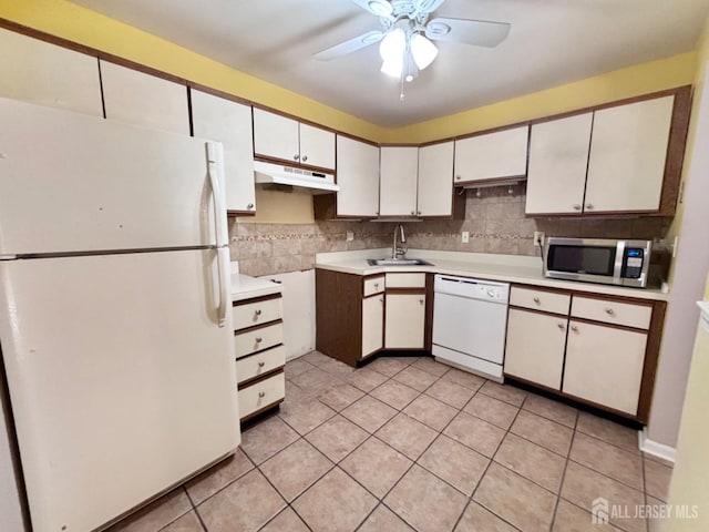 kitchen with a sink, backsplash, white appliances, ceiling fan, and under cabinet range hood