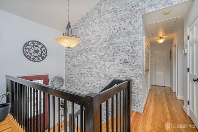 hall featuring attic access, baseboards, and wood finished floors