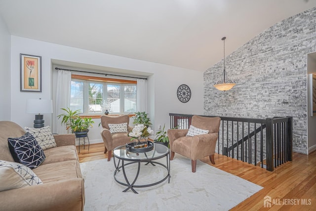 living room with lofted ceiling, wood finished floors, and baseboards