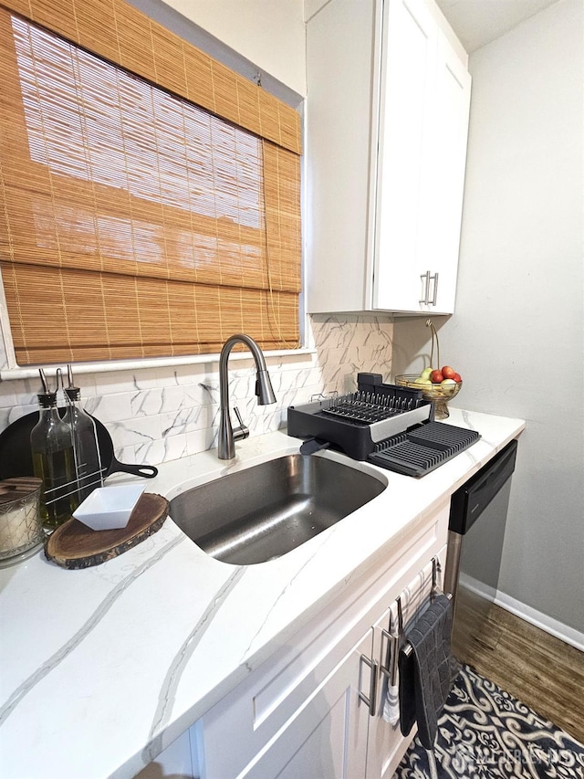 kitchen with tasteful backsplash, white cabinetry, sink, and dark wood-type flooring