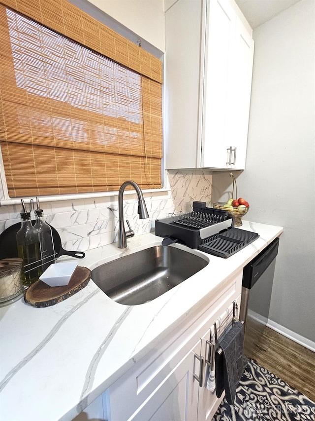 kitchen with decorative backsplash, baseboards, wood finished floors, and a sink