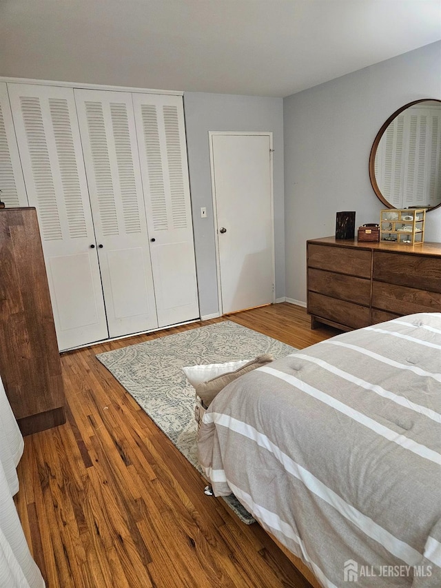 bedroom featuring wood finished floors, a closet, and baseboards