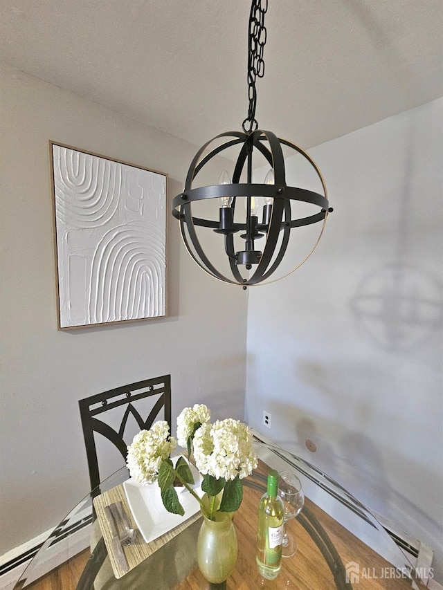 dining space with baseboard heating, wood finished floors, and a chandelier