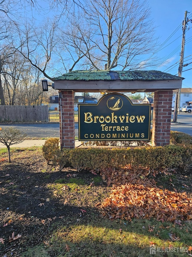 community / neighborhood sign featuring fence