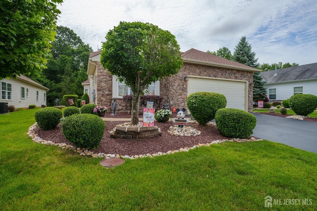 263 Valencia Dr, Monroe, NJ 08831 - obstructed view of property featuring driveway, stone siding, a garage, and a front lawn