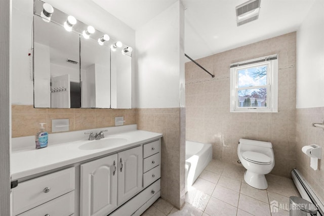 full bath featuring baseboard heating, tile walls, toilet, tile patterned floors, and vanity